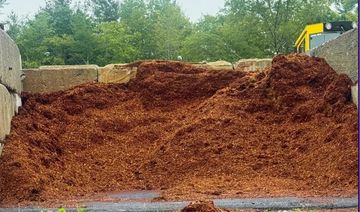 A large pile of mulch or wood chips in an outdoor storage area.