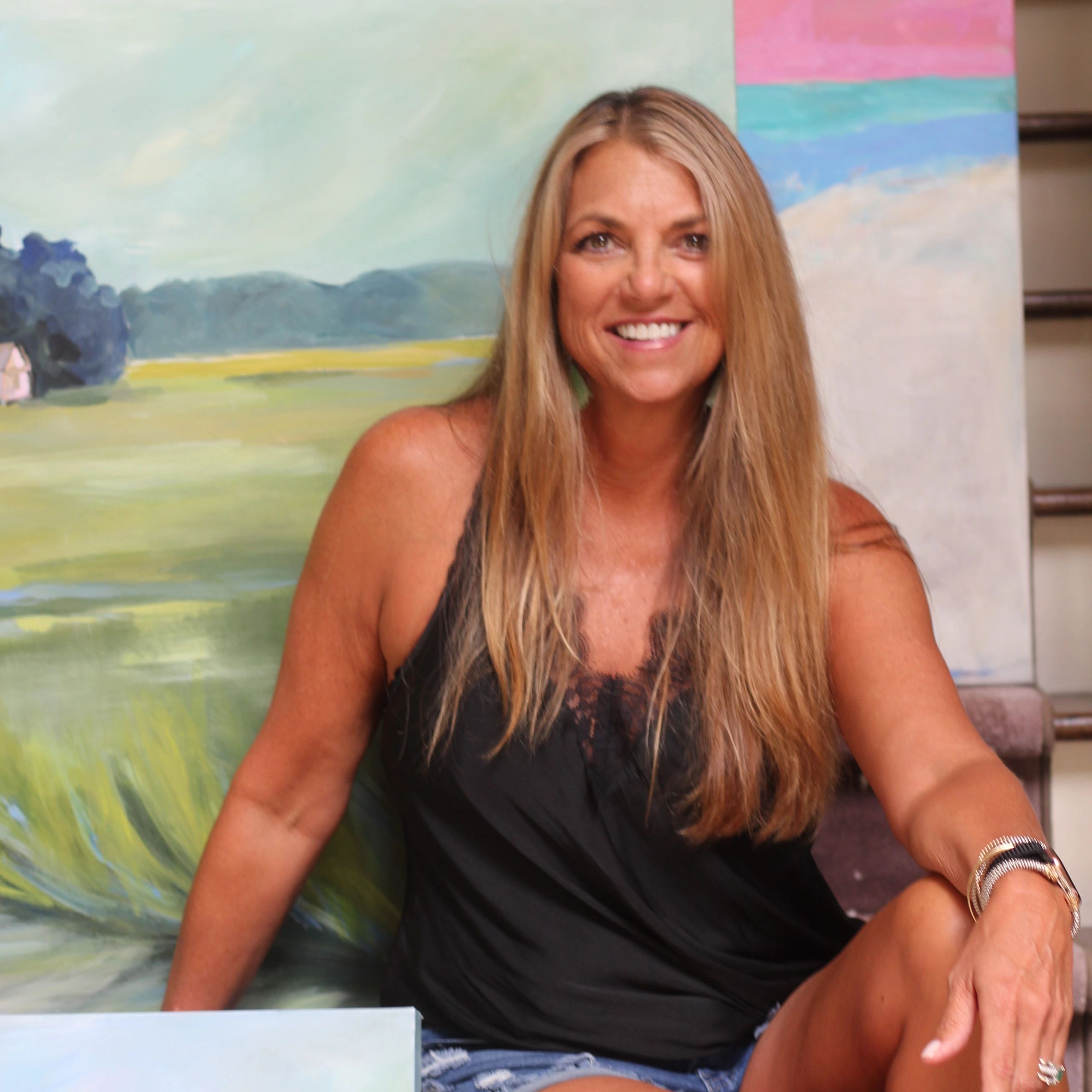 Artist Leslie Cannon. smiling with her art.