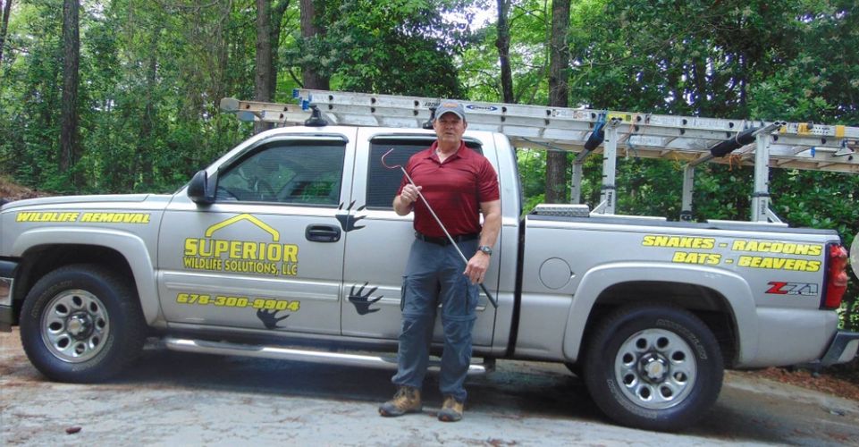 Superior Wildlife Solutions Truck with logo and owner, Glenn Horner. 