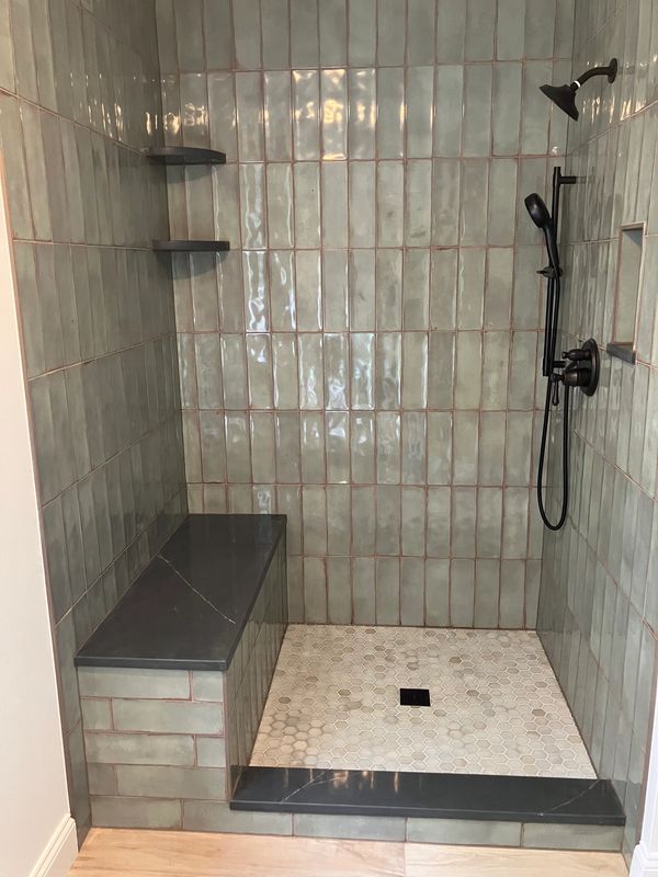 Beautifully stacked tile w/ black quartz bench, curb, shelves & niche. A hexagon mosaic to blend for