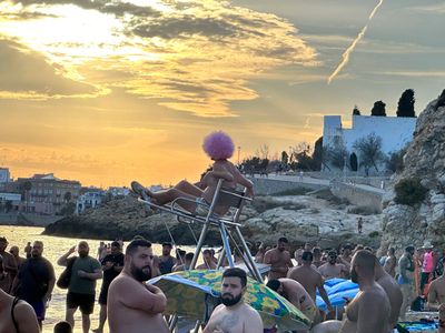 Lifeguard with a wig on at the Gay Beach in Sitges Spain