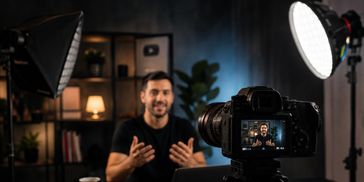 Homem gravando vídeo com câmera em estúdio.