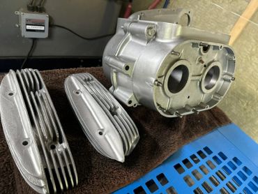Disassembled metal engine parts on a workspace.