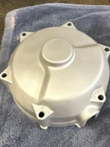 Silver metallic mechanical cover with bolt holes.