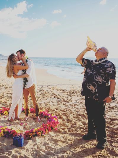 Reverend Adam Gomez blowing a conch shell.