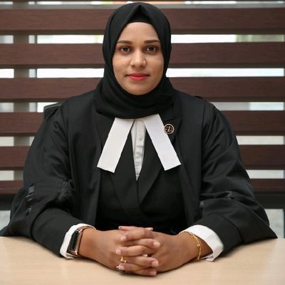 Femme avocate portant un voile et une robe noire, posant avec confiance.