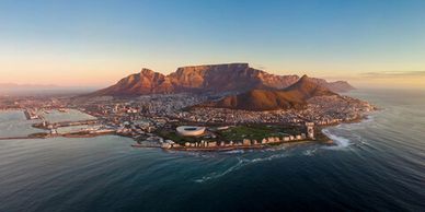Aerial view of Table Mountain and Cape Town coastline at sunset.