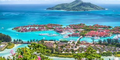 A vibrant tropical island resort with turquoise waters and lush greenery.