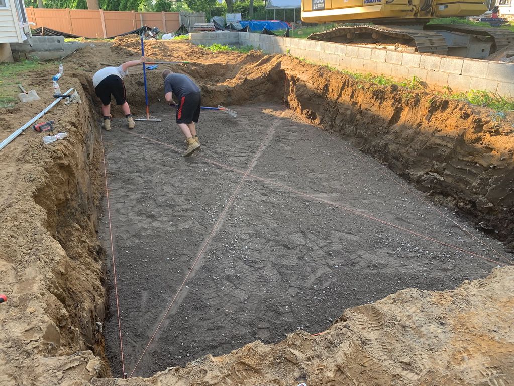 Fiberglass Pool hole excavated to pool specifications, Base is installed for pool foundation.