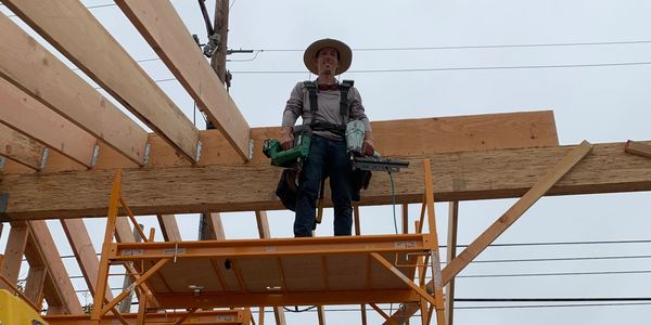 Owner of construction Company standing on scaffolding installing Cathedral Roof system