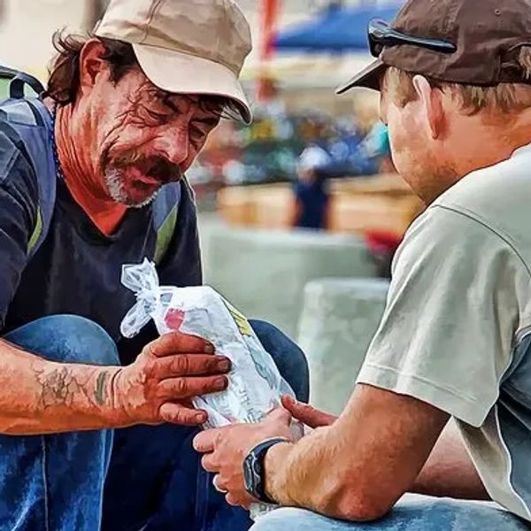 Christian gives bread to a homeless, showing Christ-like compassion to the least lost and last