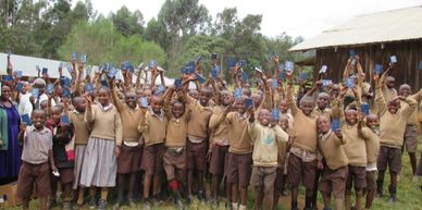 Happy children with New Testaments from The Gideons International's worldwide Bible distribution." 