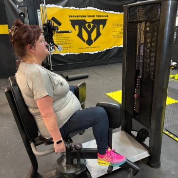 Woman exercising on a leg press machine at the gym.
