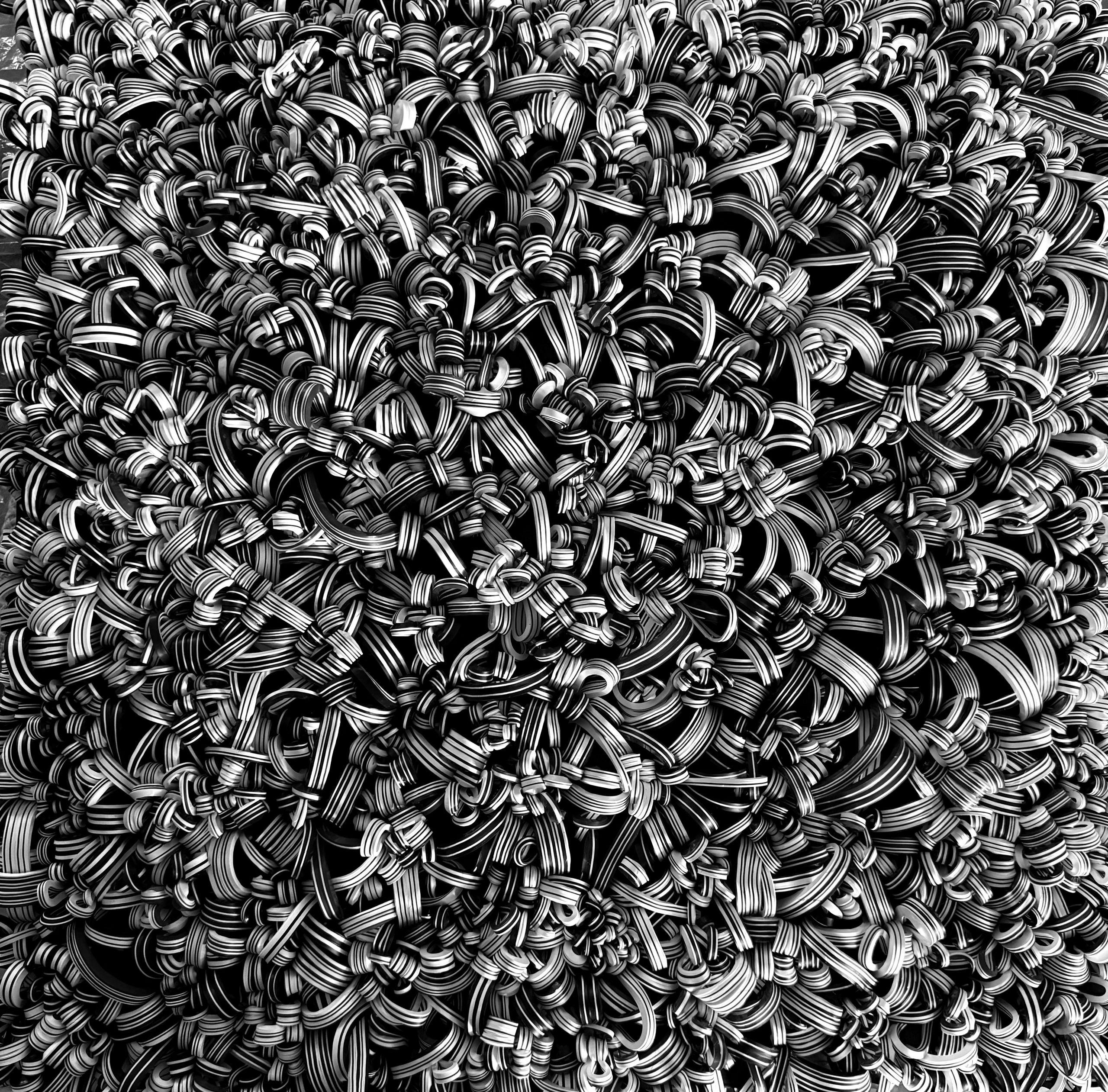 Close-up of numerous striped rubber bands tangled together.