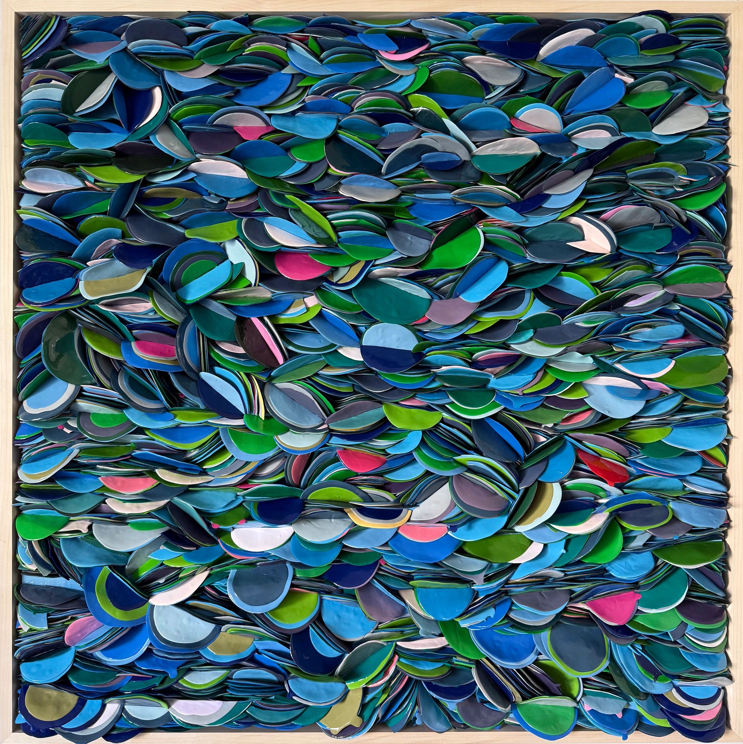 Colorful layered ceramic leaves in a wooden frame.