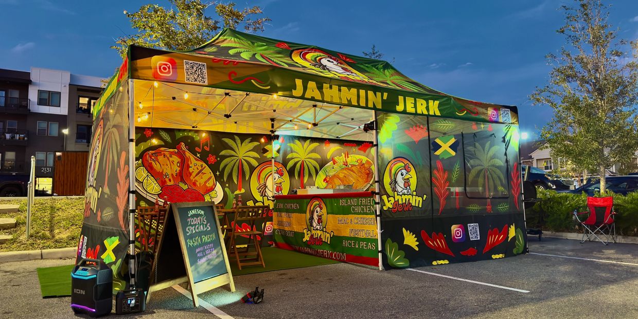 Colorful Jahmin' Jerk food tent with bright lights at dusk.
