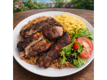 Plate with jerk chicken, rice and peas, macaroni and cheese, and salad.