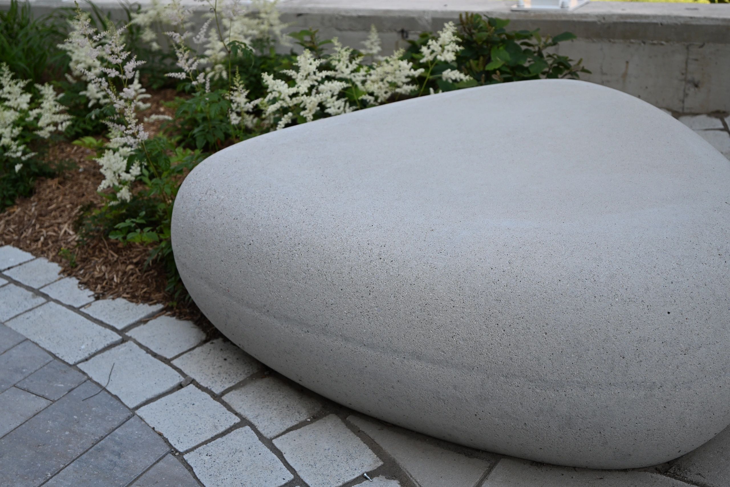 Modern stone bench in a garden setting.