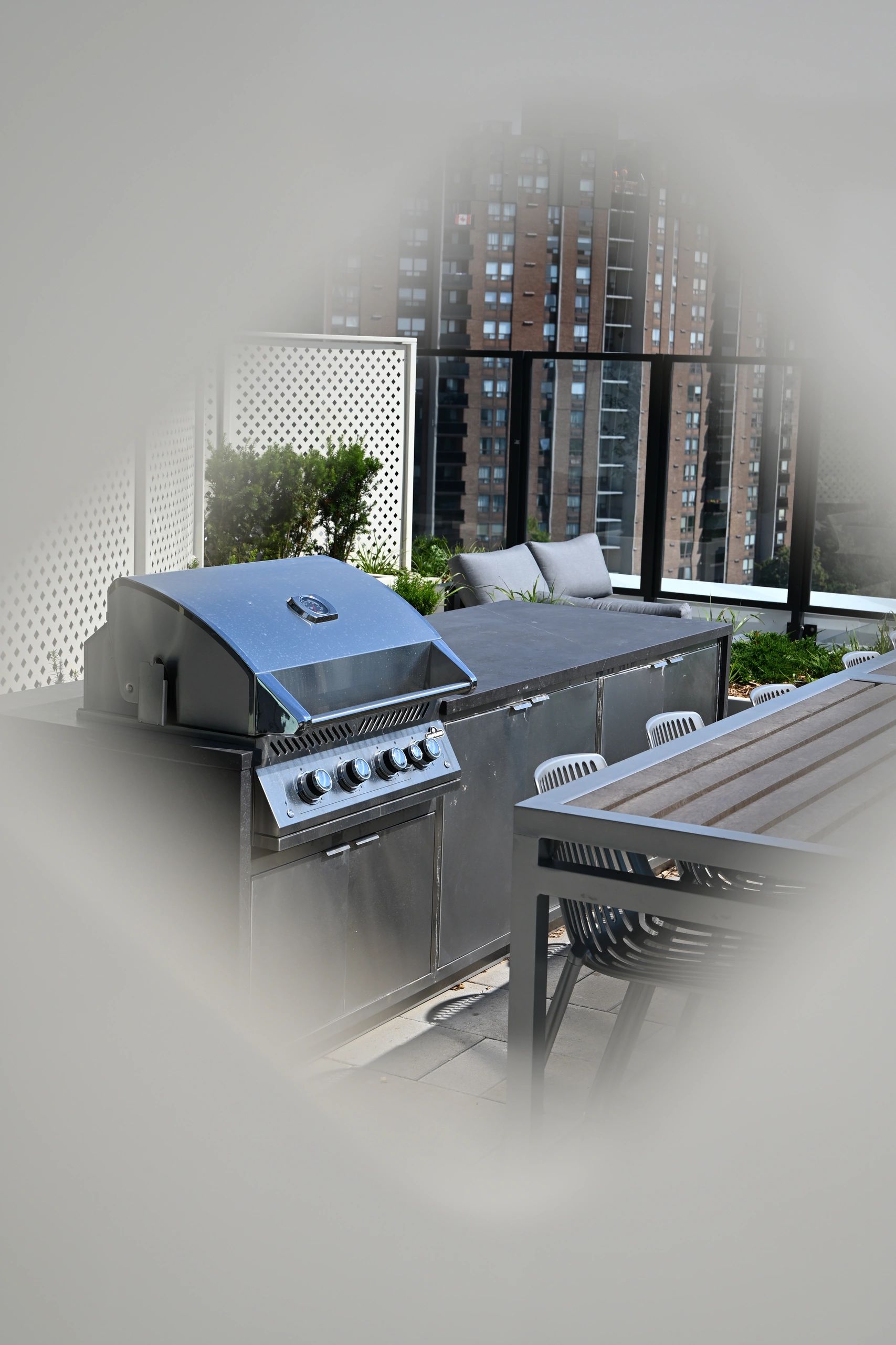 Urban outdoor patio with barbecue grill and seating.
