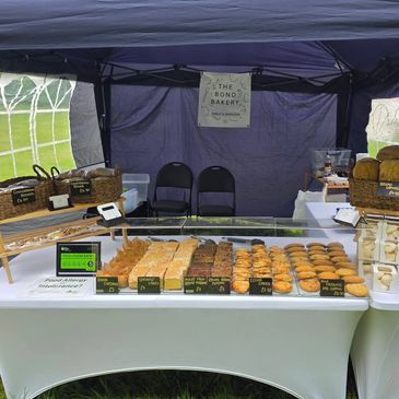 Bakery stall showcasing an assortment of baked goods under a tent.