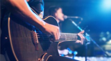 Man playing the guitar while a girl sings