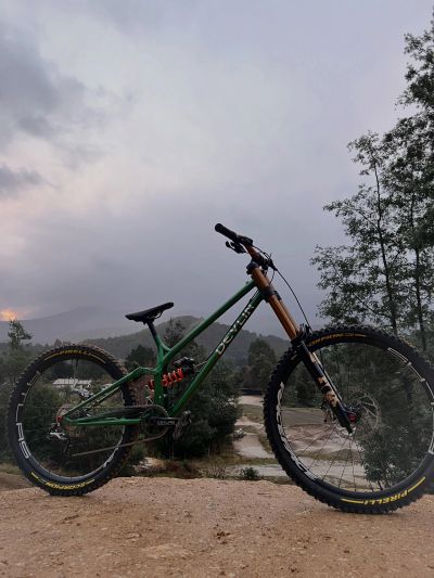 Mountain bike on a dirt trail with a scenic forest background.
