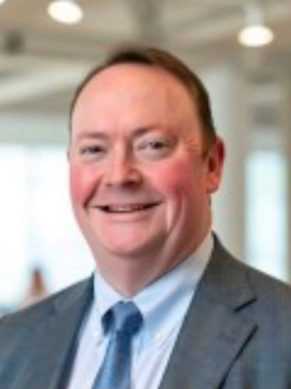 Smiling man in a suit and tie.
