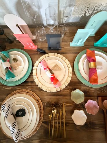 Colorful, elegant table setting with numbered cards and glassware.