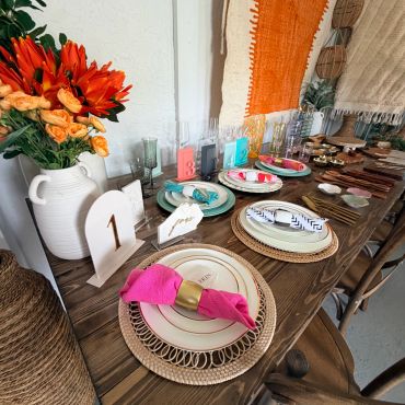 Beautifully set rustic table with colorful napkins and floral centerpiece.