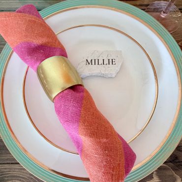 Place setting with a name card and colorful napkin.