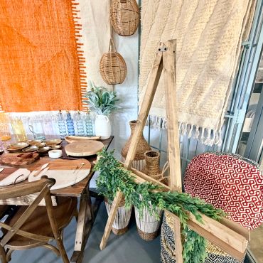 Rustic dining setup with wooden furniture and greenery.
