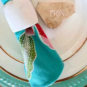 Personalized name tag and colorful napkin on a plate.