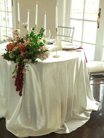 Elegant wedding table with floral centerpiece and candles.
