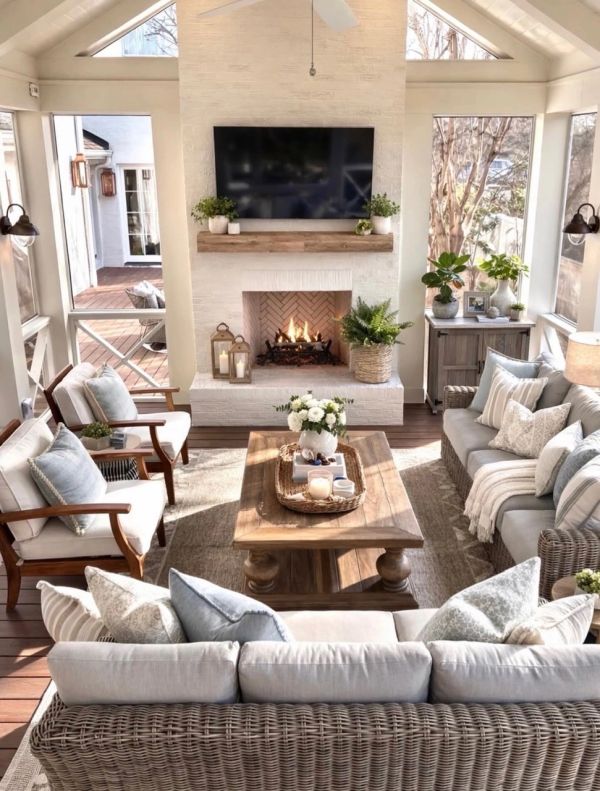 Cozy sunlit living room with fireplace and wicker furniture.