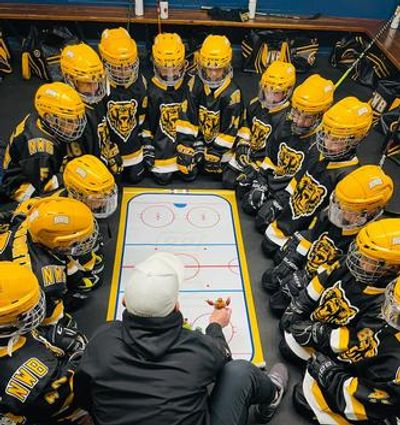 Coach explaining hockey rink tactics.