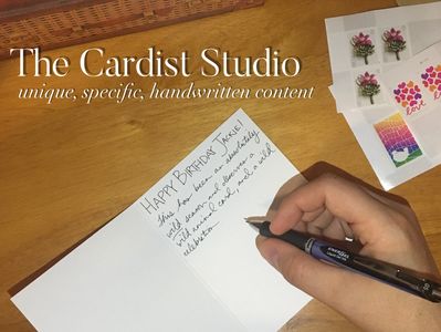 A hand writing a birthday card, postal stamps to the side. In white text overlay The Cardist Studio.