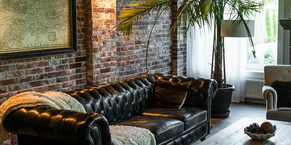 Cozy living room with leather sofa and brick wall.