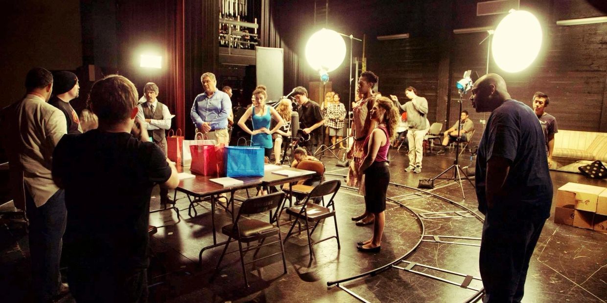 Group of people on a film set with lighting equipment.