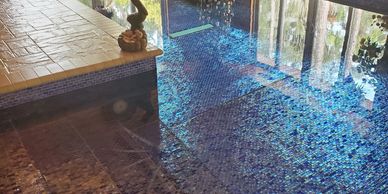 Indoor pool with blue mosaic tiles and Christmas decorations.