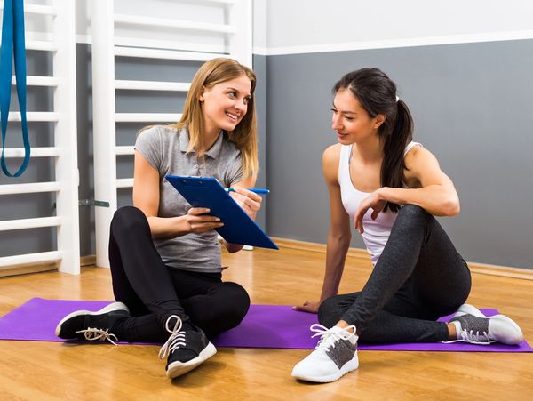 Woman and her personal trainer talking