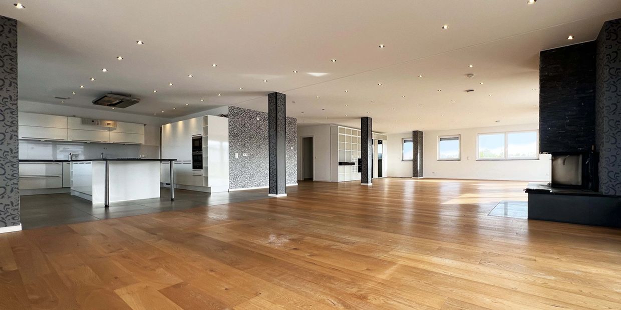 Spacious modern open-plan kitchen and living area with wooden floors.