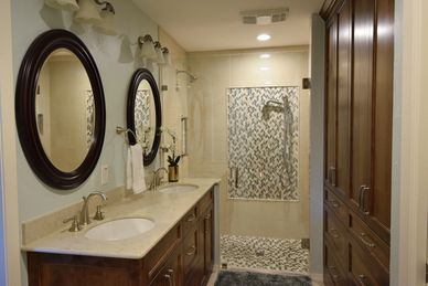 bath room with shower, two sinks, two mirrors, wall mounted lighting