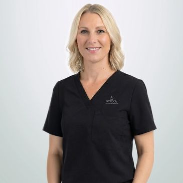 Smiling woman in black medical scrubs.