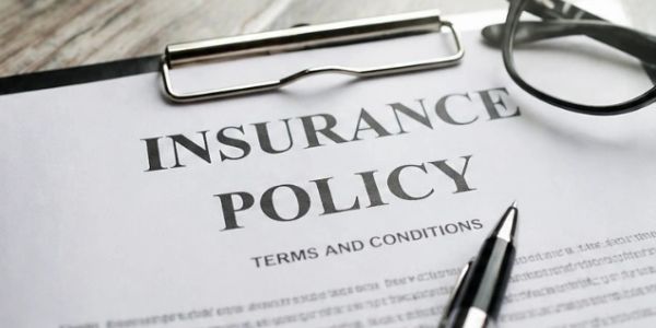 Close-up of an insurance policy document with pen and glasses.