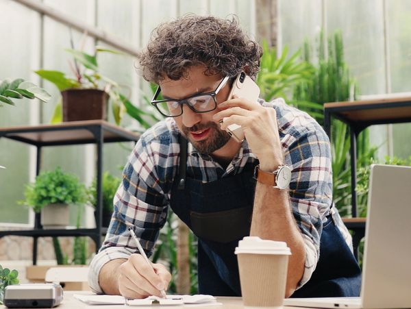A small business owner speaking with a client over the phone