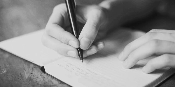 Una persona escribe en una libreta.