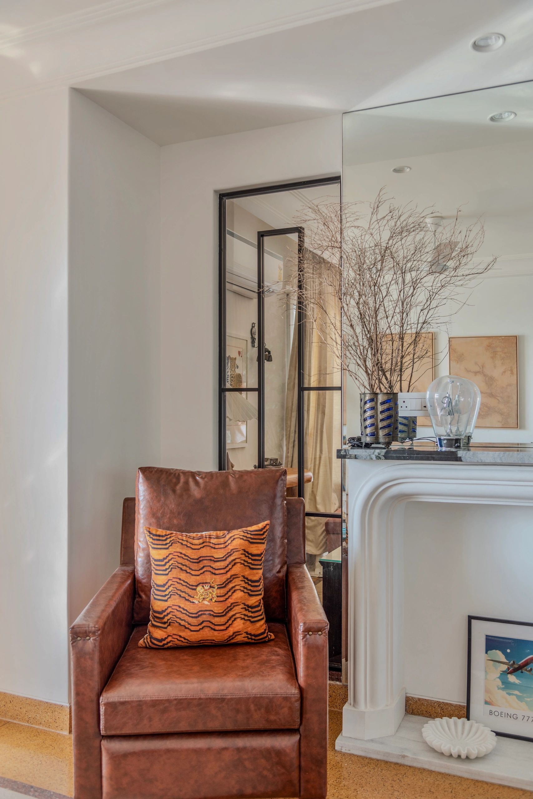 Cozy leather armchair with a tiger-striped cushion in a stylish living room.