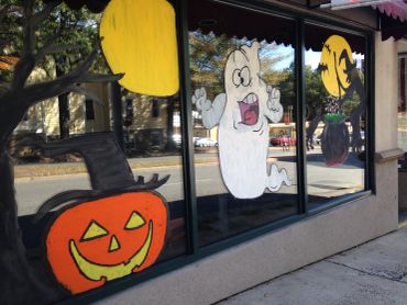 Halloween-themed window decorations with a pumpkin, ghost, and bats.