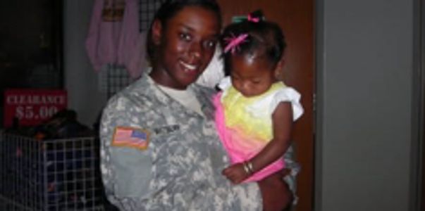 Soldier holding a small child.