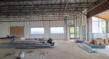 Interior of a building under construction with materials scattered.